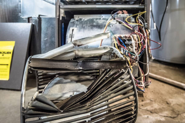 Damaged industrial fan with exposed wiring in mechanical workshop