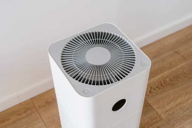 White square air purifier with circular ventilation grid on wooden floor