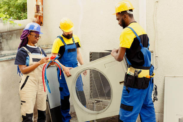 HVAC technicians installing or repairing a large air conditioning unit