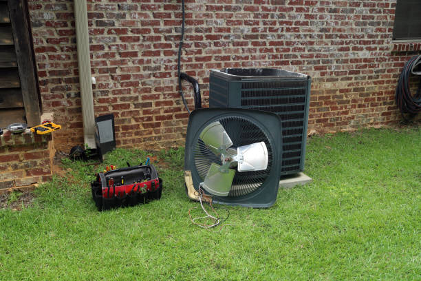 HVAC technician's tools and air conditioning unit on grassy yard