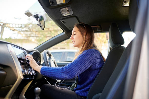 Woman in blue sweater driving car with focused expression