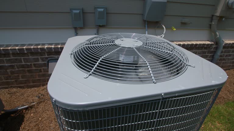 Outdoor air conditioning unit with large fan on residential building