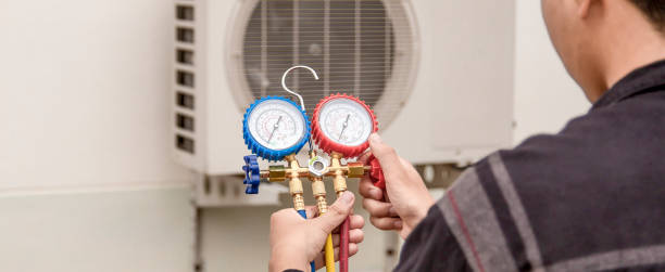 Technician checking air conditioning system with pressure gauge manifold