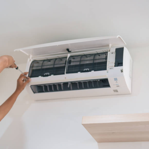 Hand adjusting wall-mounted white air conditioning unit