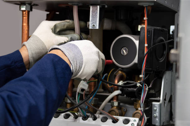 Technician's gloved hand repairing electrical components inside machinery