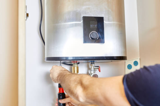 Technician repairing or adjusting a white water heater with tools