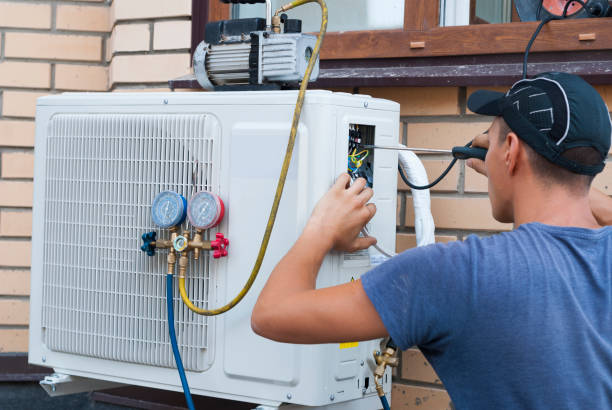 Technician repairing air conditioning unit with diagnostic tools and gauges
