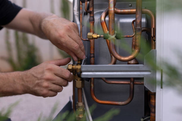 Hands adjusting copper pipes and connections on a mechanical system