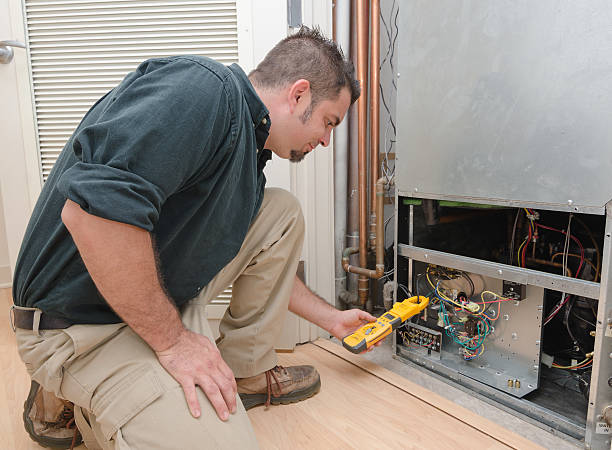 Technician using multimeter to diagnose electrical issues in HVAC system