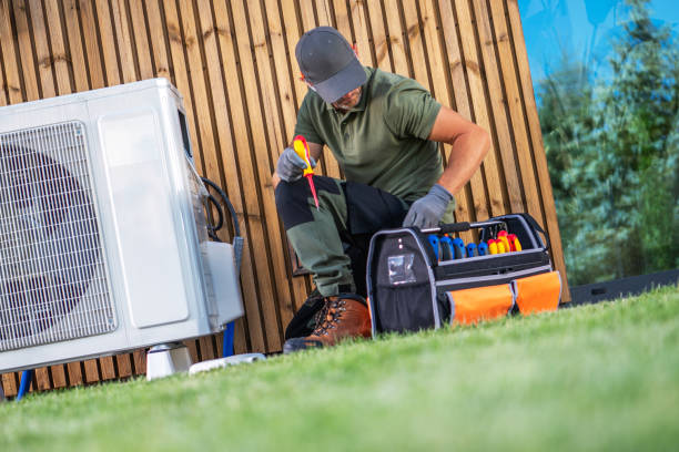 HVAC technician checking outdoor air conditioning unit with tool bag