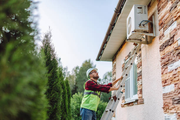 Worker in safety vest checks air conditioning unit on building exterior