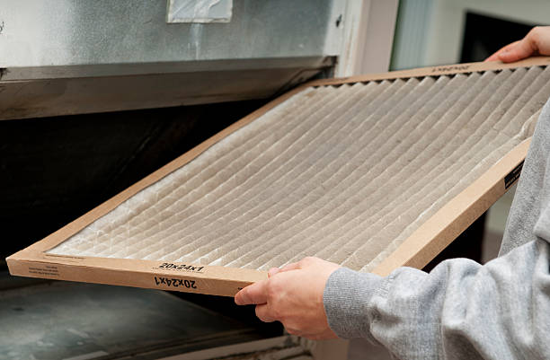 Hands holding a clean, pleated air filter for home HVAC system