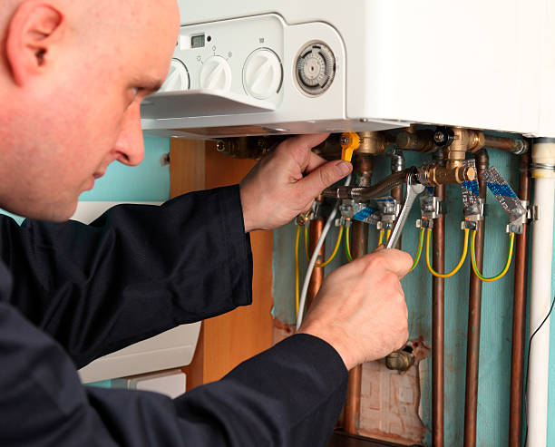 Technician repairing electrical connections inside a heating system