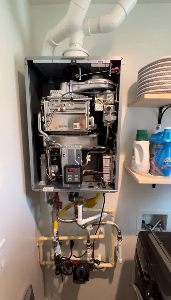 Open tankless water heater showing internal components and plumbing