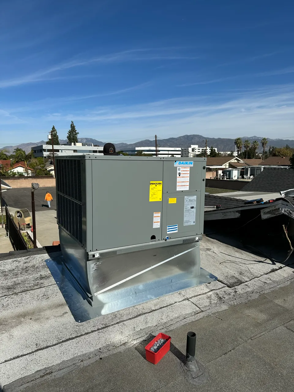 Daikin HVAC unit installed on a flat roof with mountains in background