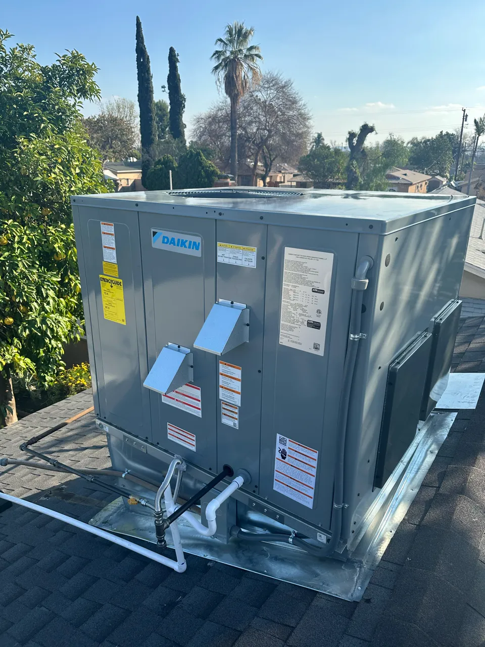 Daikin HVAC unit installed on a residential roof with palm trees
