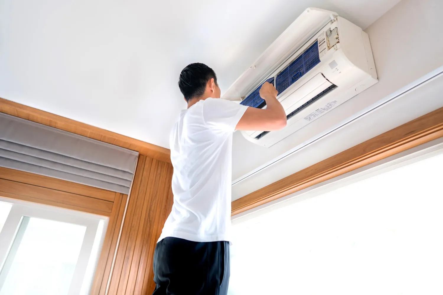 Man installs filter in mini-split AC.