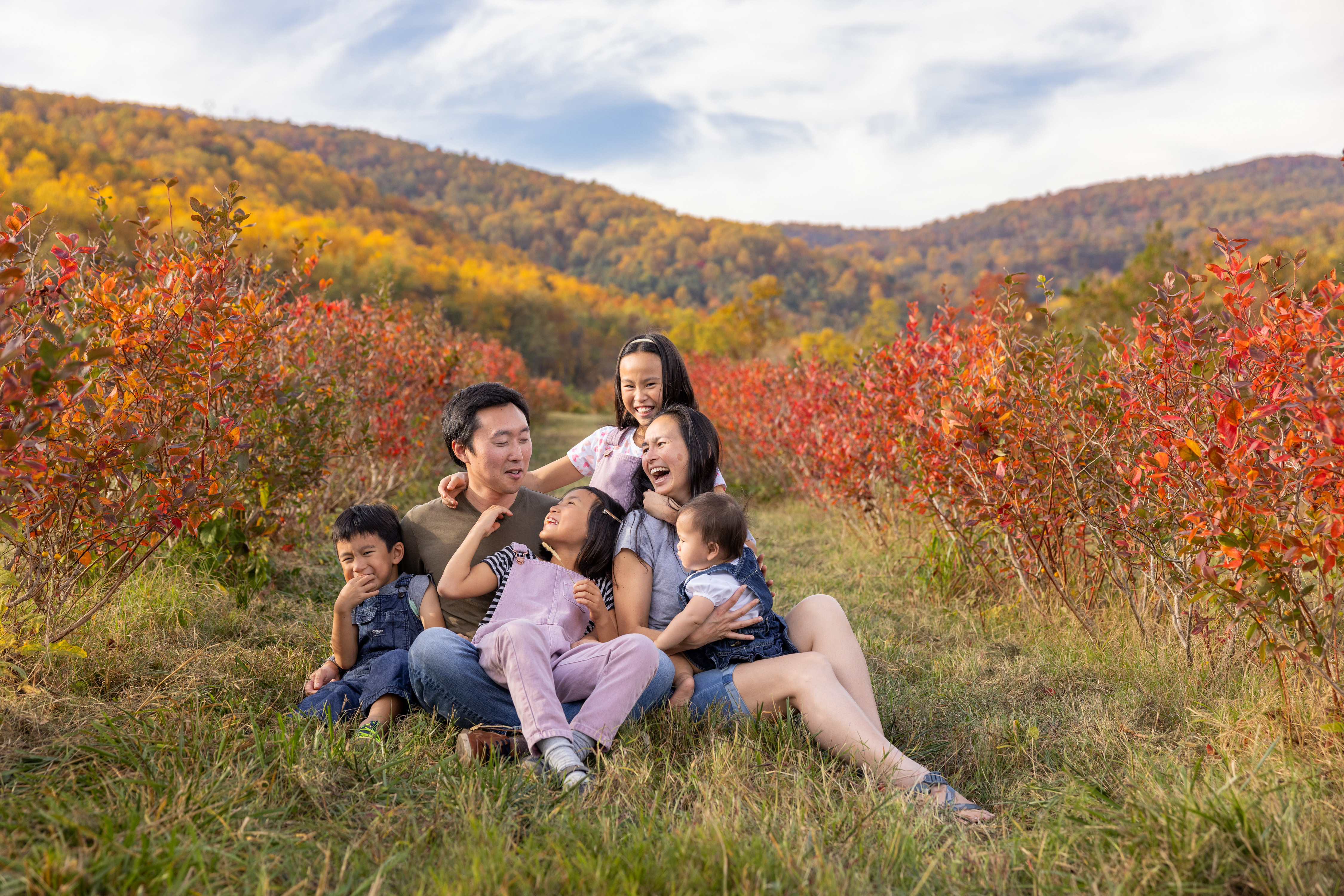 A family laughs with each other during their fall portraits in Charlottesville Virginia