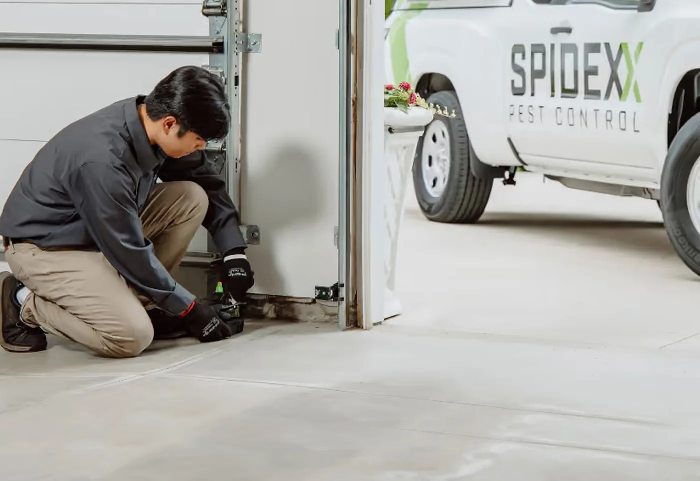 A Spidexx technician treating a garage doorway