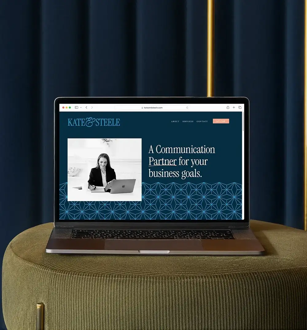 Kate & Steele's website home page displayed on a laptop. Dark, moody, and velvety colors are present in both the website design and in the background.