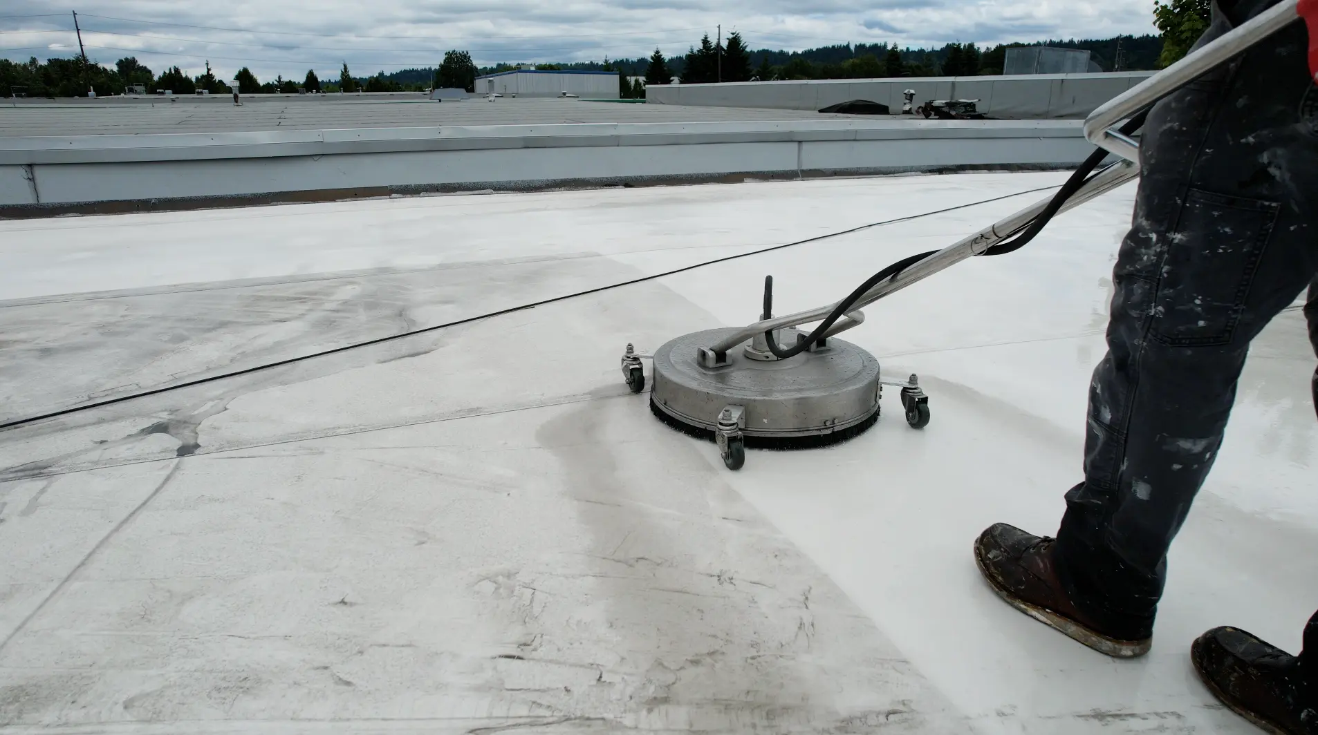 Flat Roof Pros roofer pressure washing flat TPO roof.