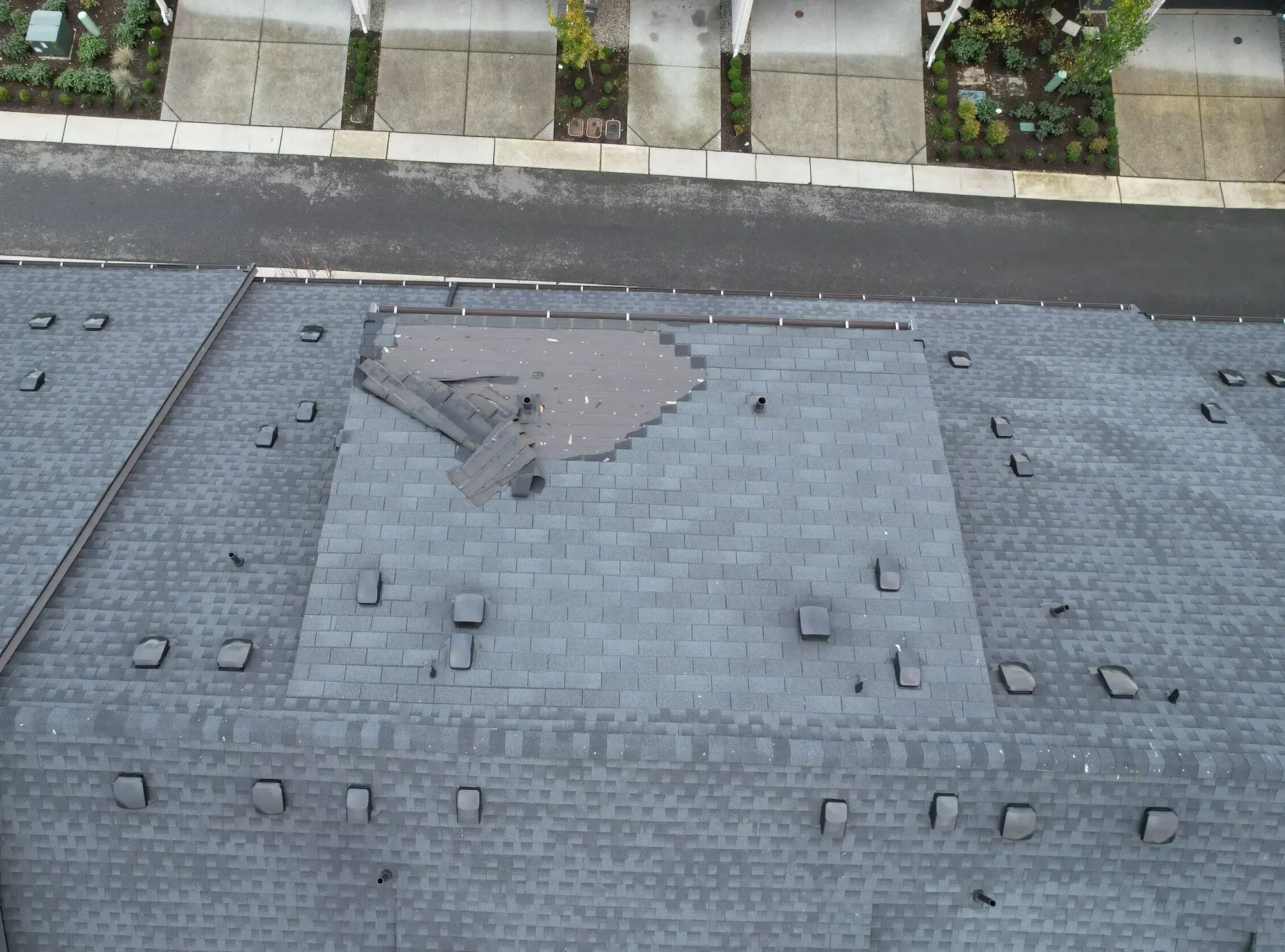 Segment of missing shingles on pitched roof.