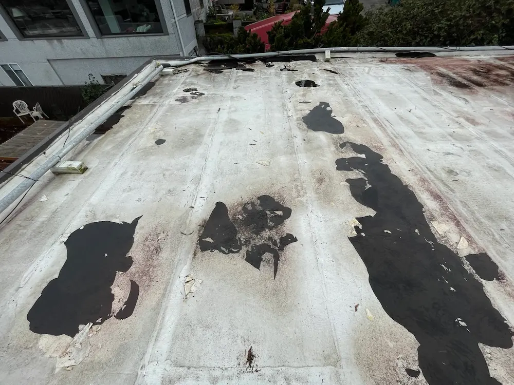 Roof membrane peeling due to poor installation.