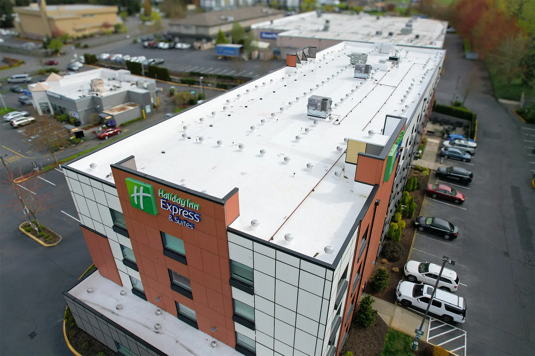 Commercial flat roof replacement on hotel building — new white TPO membrane installed for improved energy efficiency, UV protection, and long-term waterproofing by Flat Roof Pros.