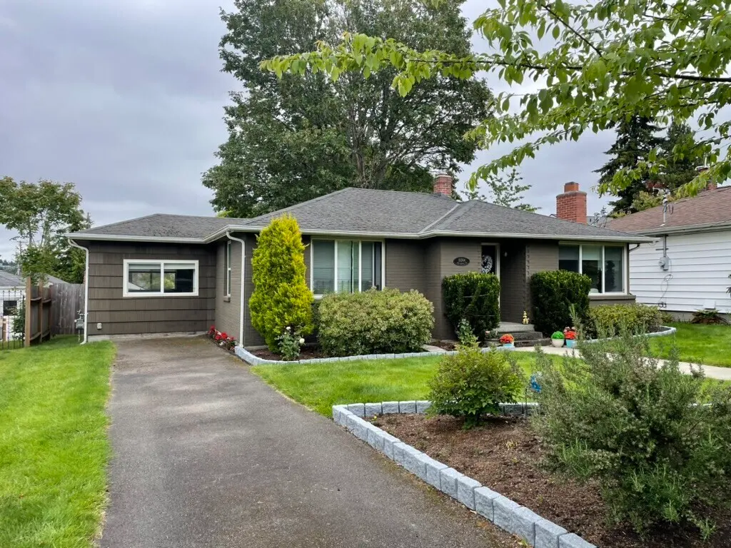 Front view of a single-story residential home with asphalt shingle roofing and landscaped yard, showing well-maintained exterior and curb appeal.