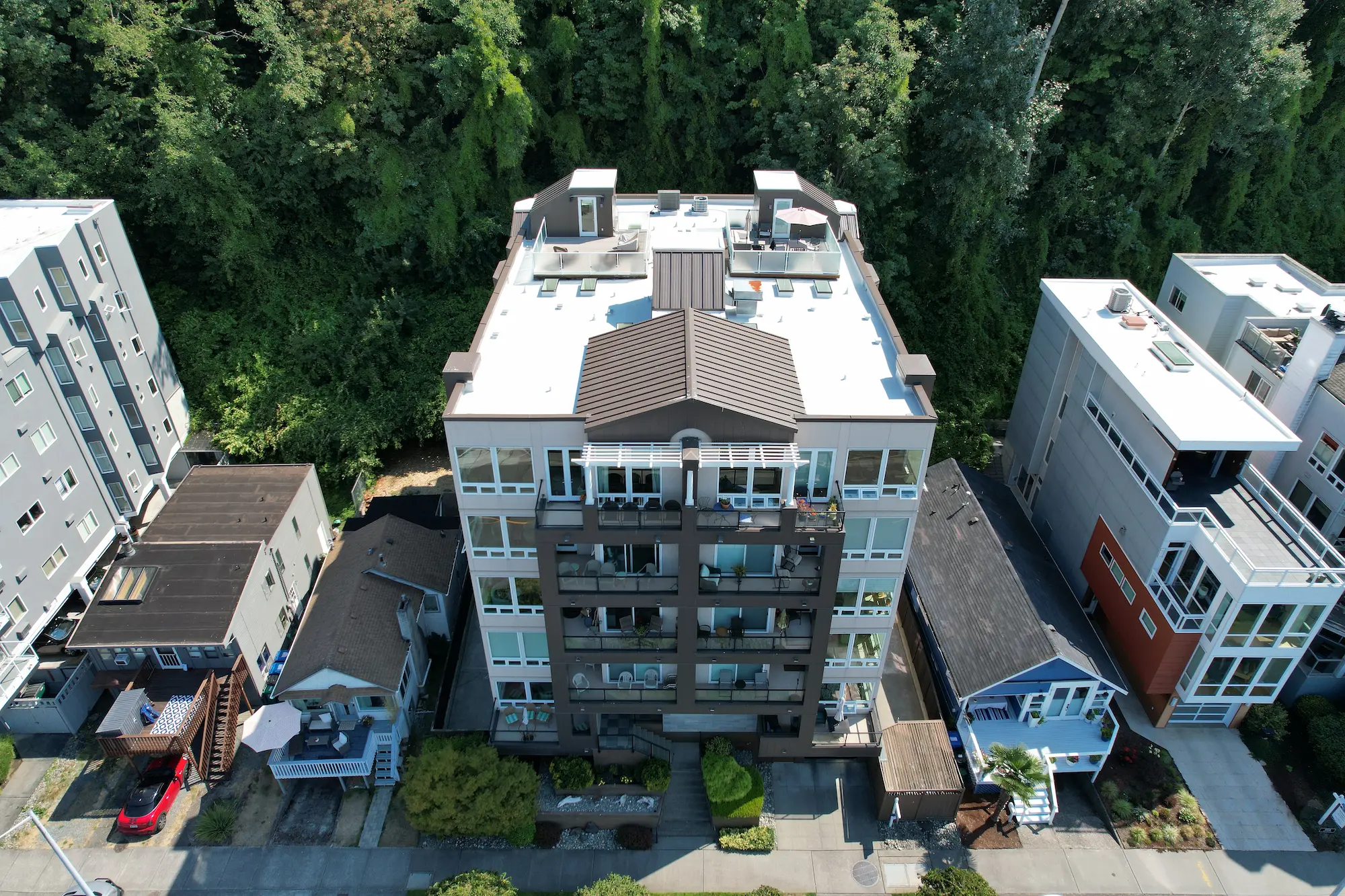 Modern multi-story apartment building in Seattle featuring a new white PVC flat roof installation by Flat Roof Pros
