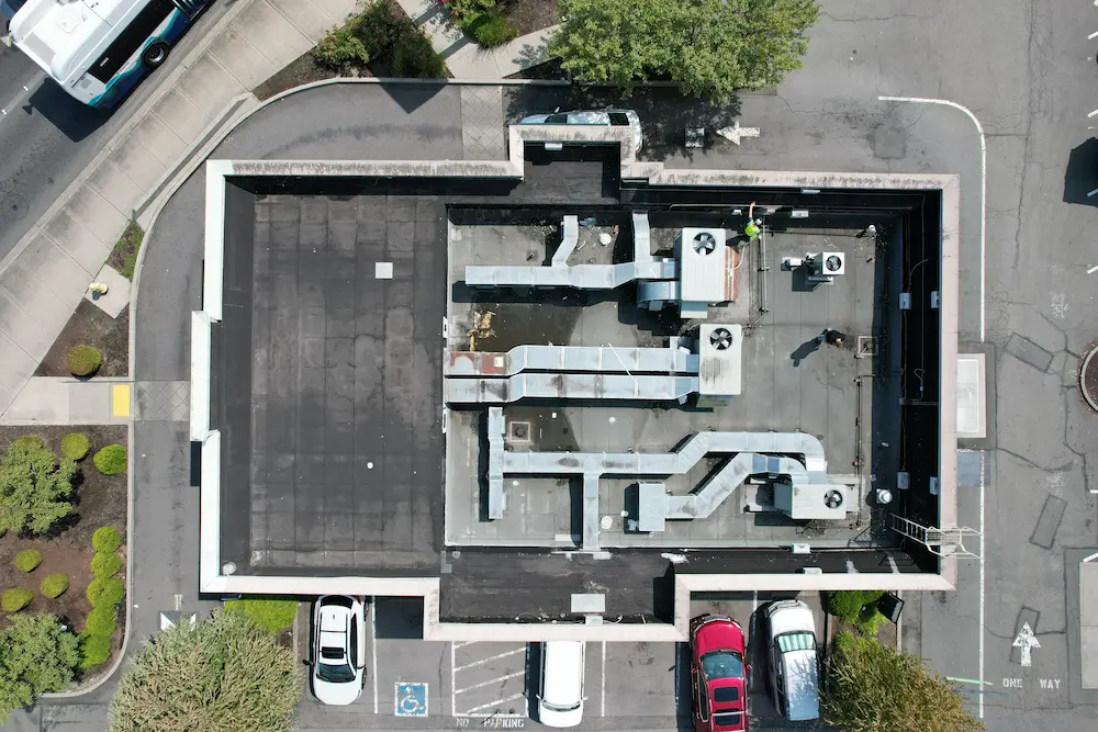 High-resolution top-view photo of a Starbucks commercial flat roof needing restoration, used in Flat Roof Pros Inc.’s assessment for property managers seeking long-term roofing solutions in Washington.