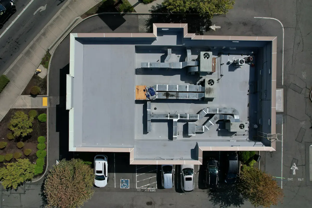 Aerial photo capturing the finished commercial flat roof upgrade on a Starbucks location, highlighting improved drainage, reinforced perimeter details, and long-term protective coating.
