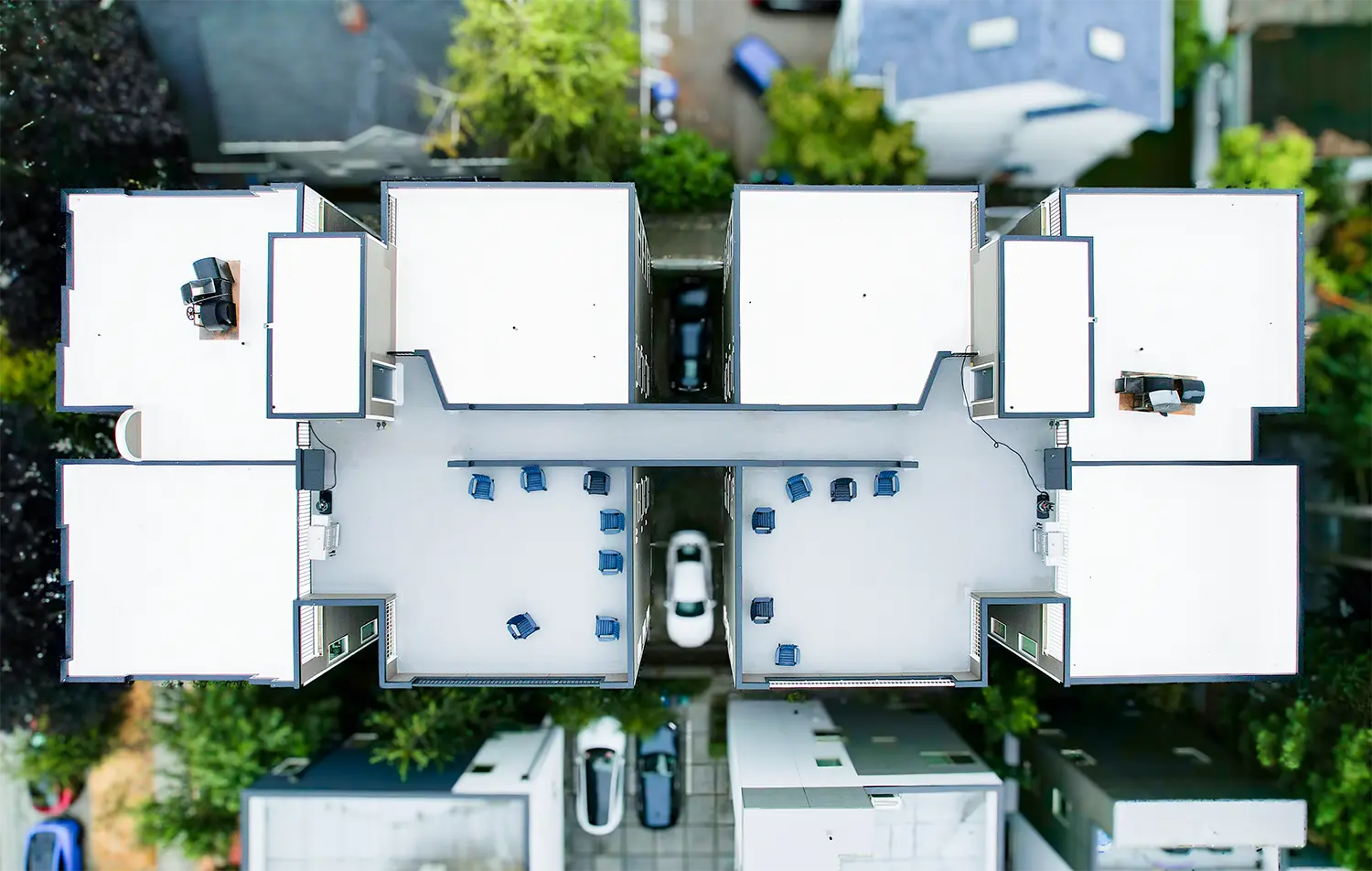 Aerial view of a Seattle apartment building with a newly installed white PVC flat roof and rooftop deck by Flat Roof Pros