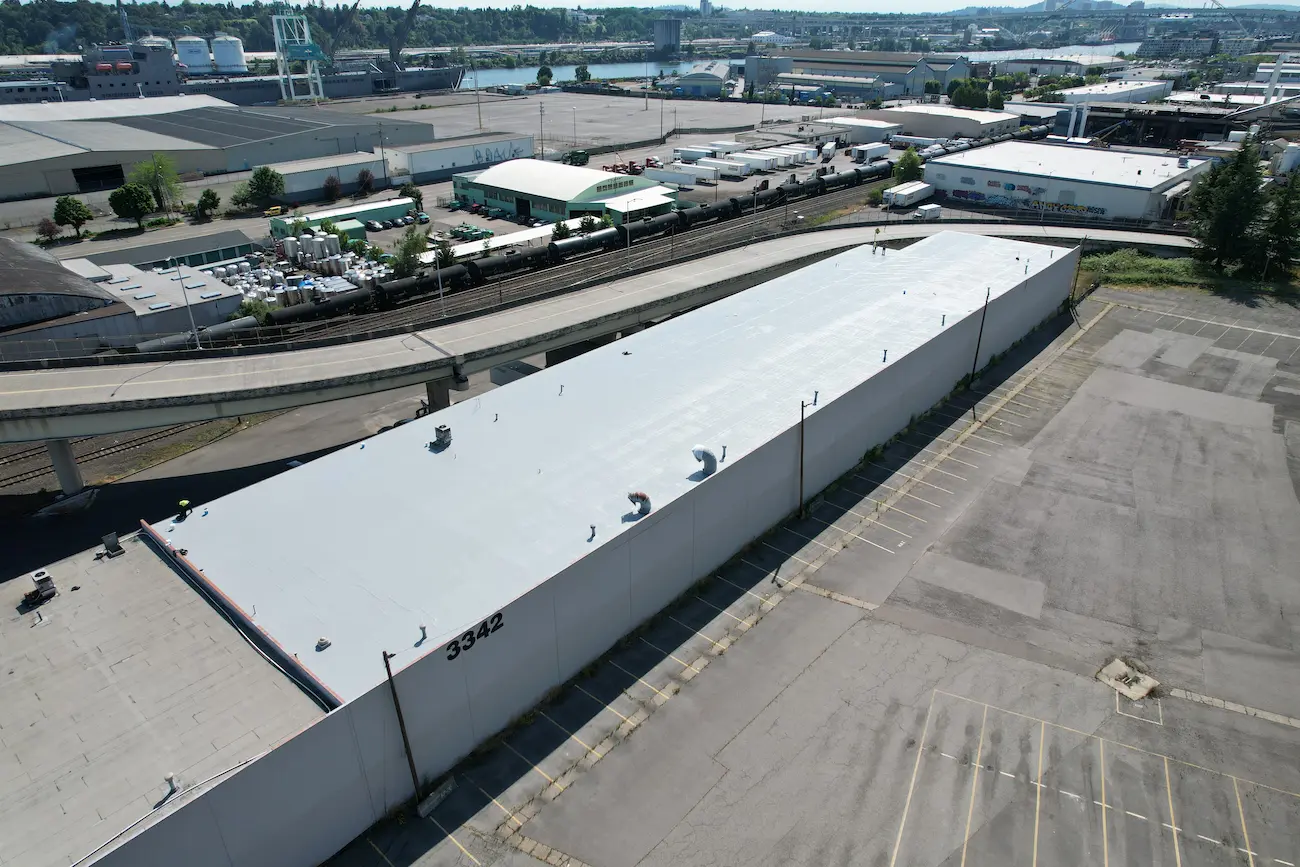 Drone image highlighting the fully restored roof with new silicone coating next to the neighboring attached roof that remained in its original condition."