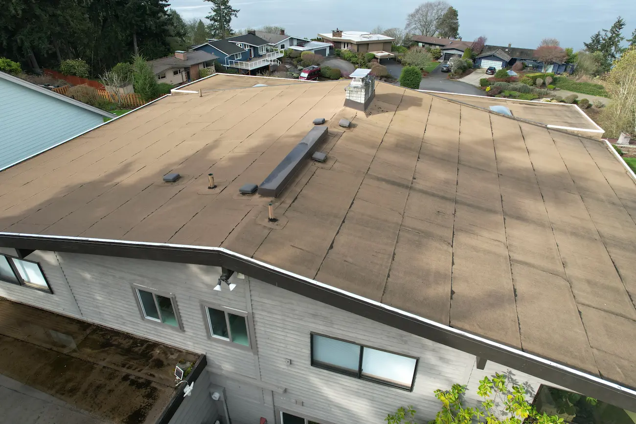 Aged and weathered flat roofing system showing surface wear and failed seams before TPO roof replacement