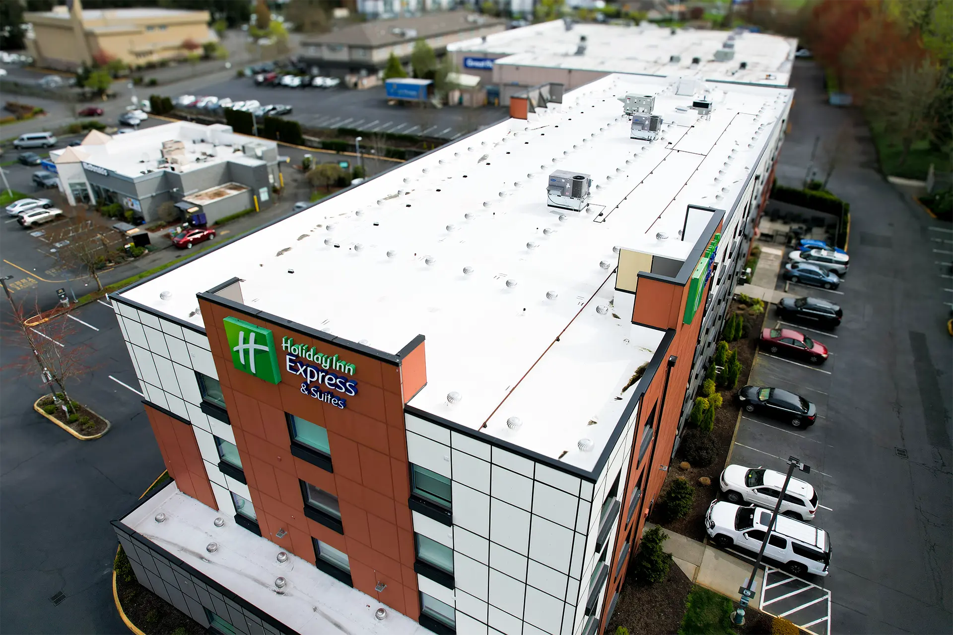 Aerial view of completed PVC roof replacement on the Holiday Inn Express hotel, showing a fully restored commercial flat roof system