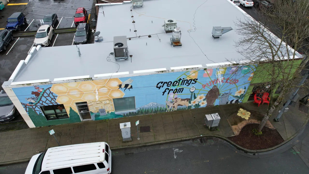 Completed white single-ply membrane roof on a commercial building in the Pacific Northwest.