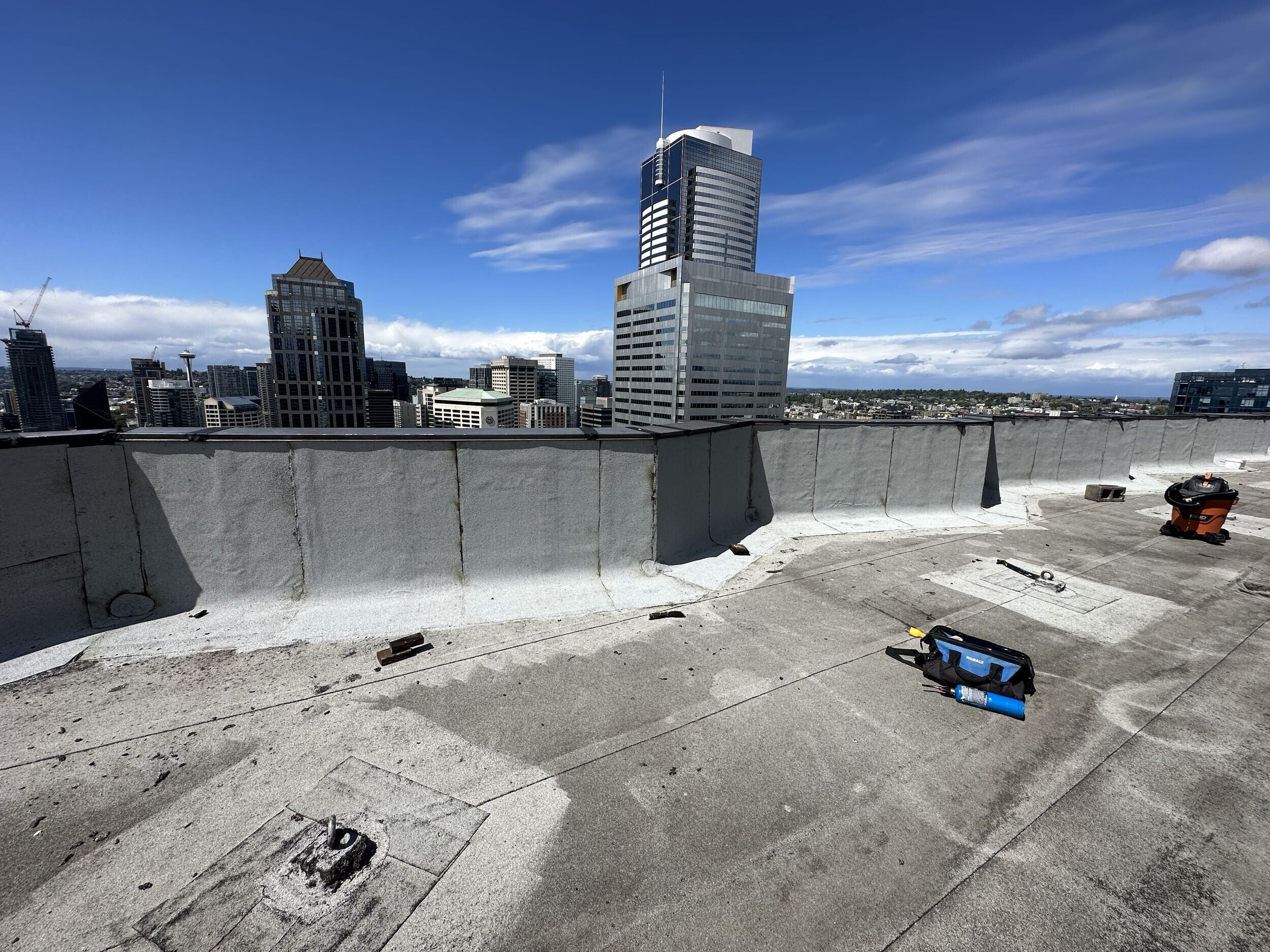 Commercial roof proposals and inspection photos being compared by a property manager