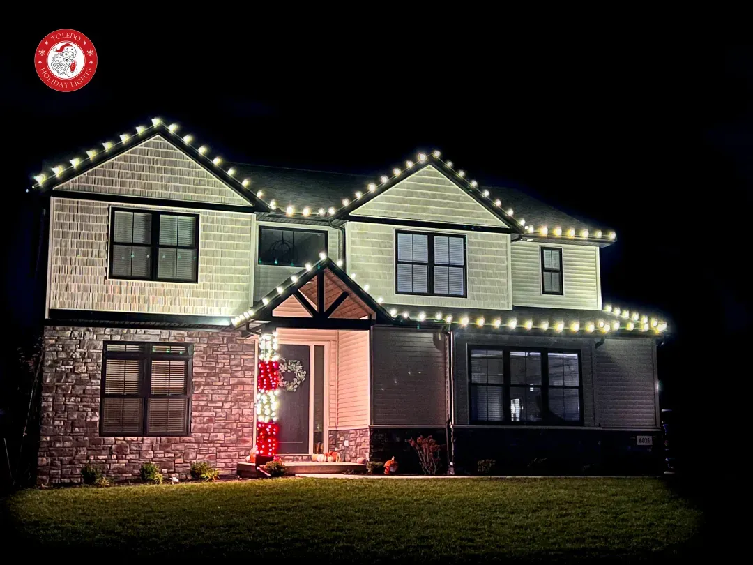 Two-storey home with white roofline lights and a lit front porch