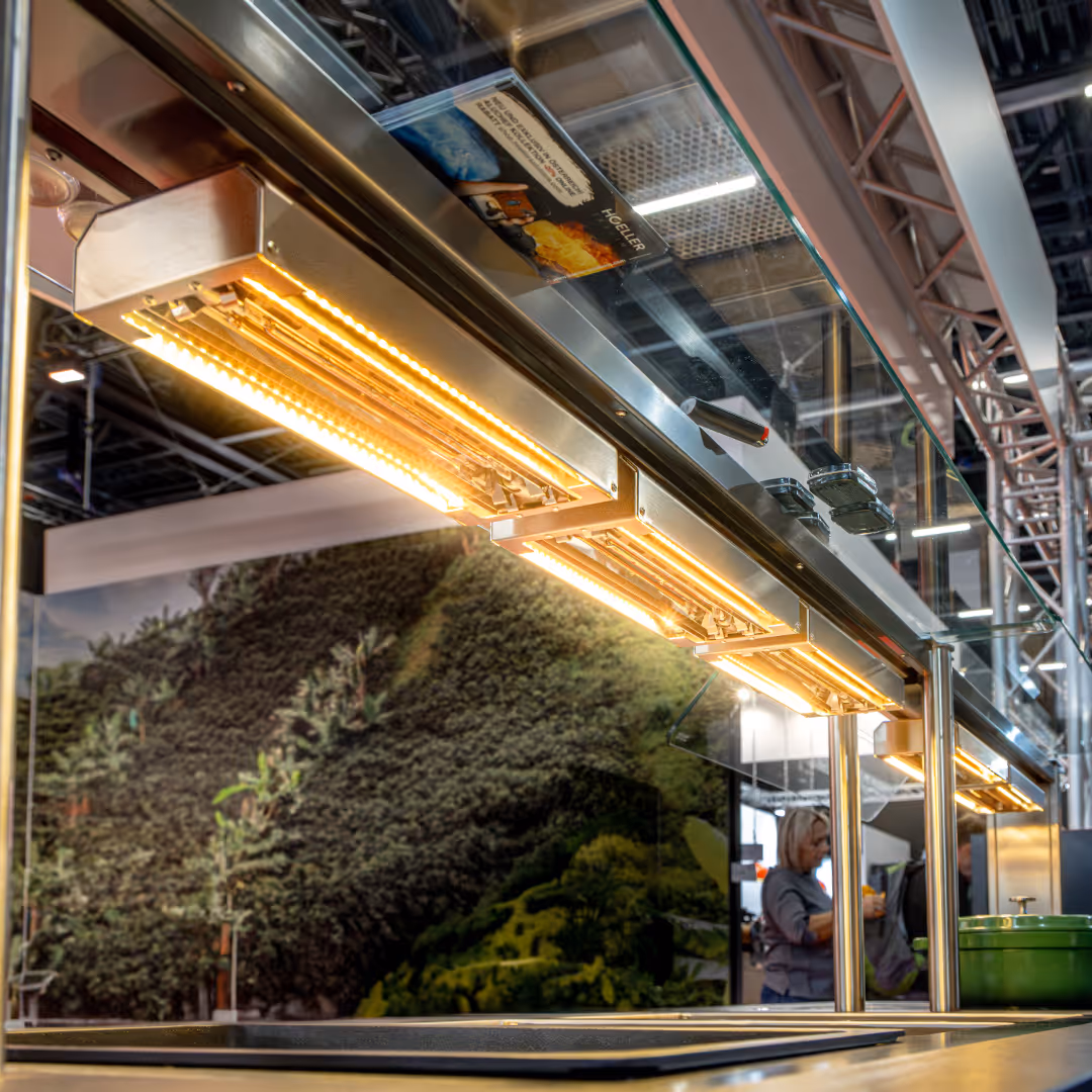 Osvětlovací zařízení s teplým světlem nad pracovní plochou v moderním interiéru.