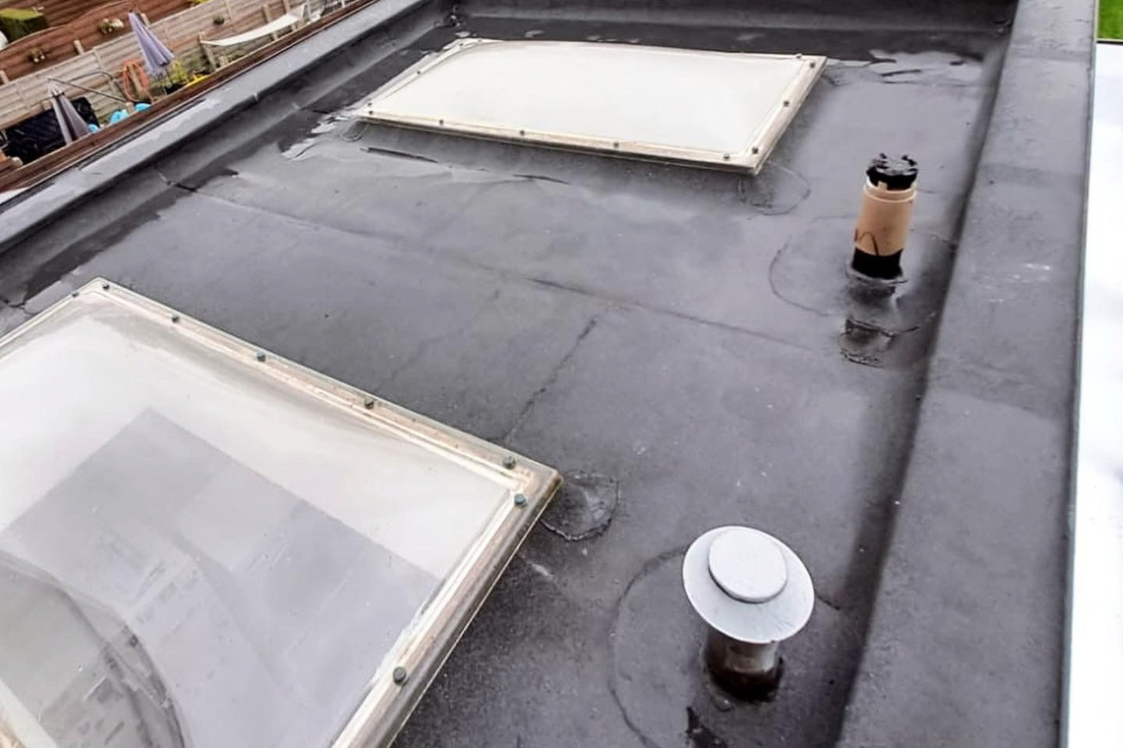 Toit plat terminé avec une couverture bitumineuse étanche et des coupoles pour plus de lumière et de ventilation.