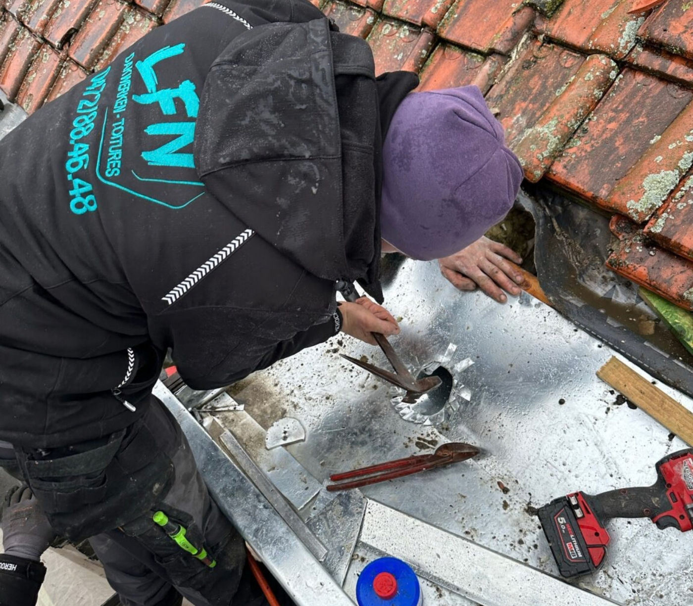 Dakwerker van LFN Dakwerken maakt een uitloop voor de regenpijp in een nieuwe zinken dakgoot.