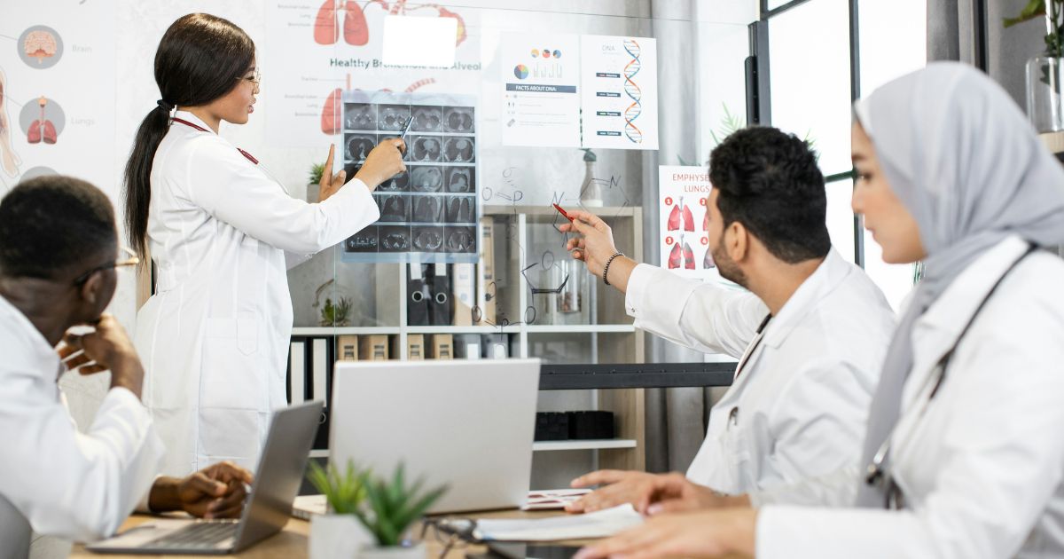 A diverse team of medical scientists analyzing X-rays during an industry research collaboration meeting.