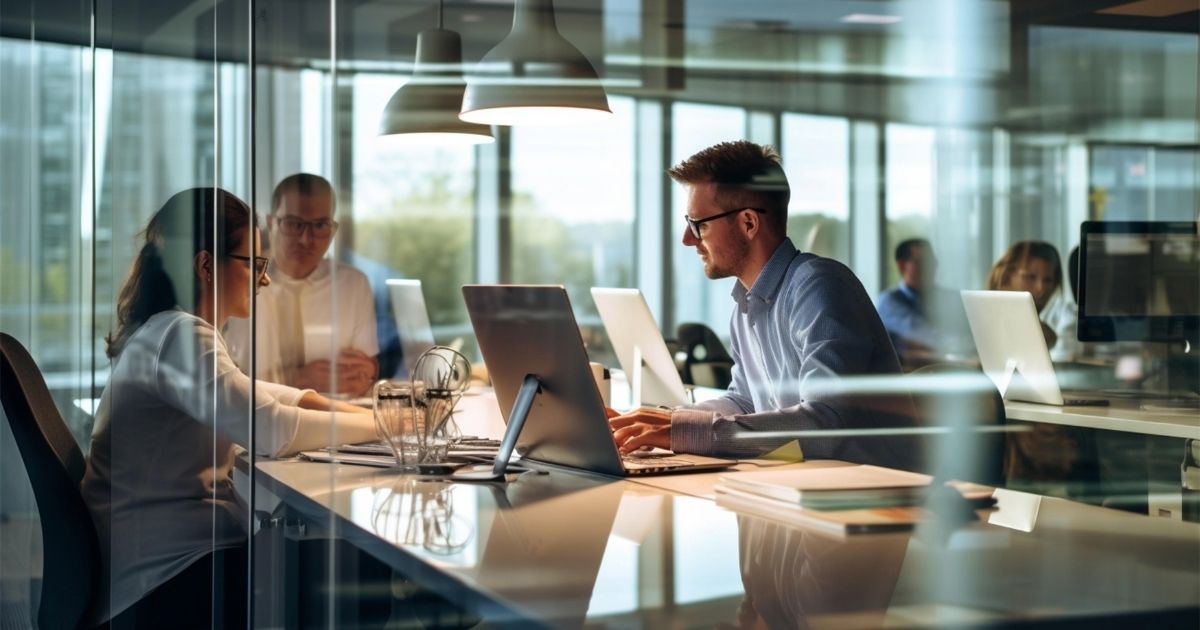 Researchers discussing an industry project in a corporate office while transitioning from academic research