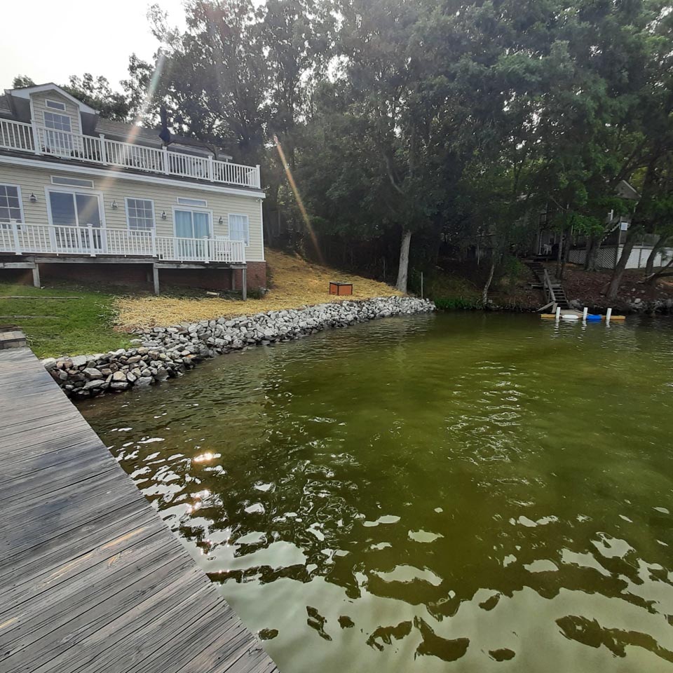 A clean shoreline with different new rock wall installed and shoreline cleaned up.