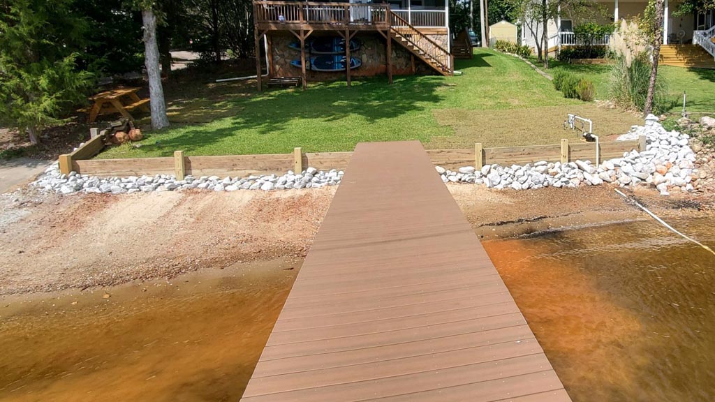A very sleek and well maintained shoreline behind a dock.