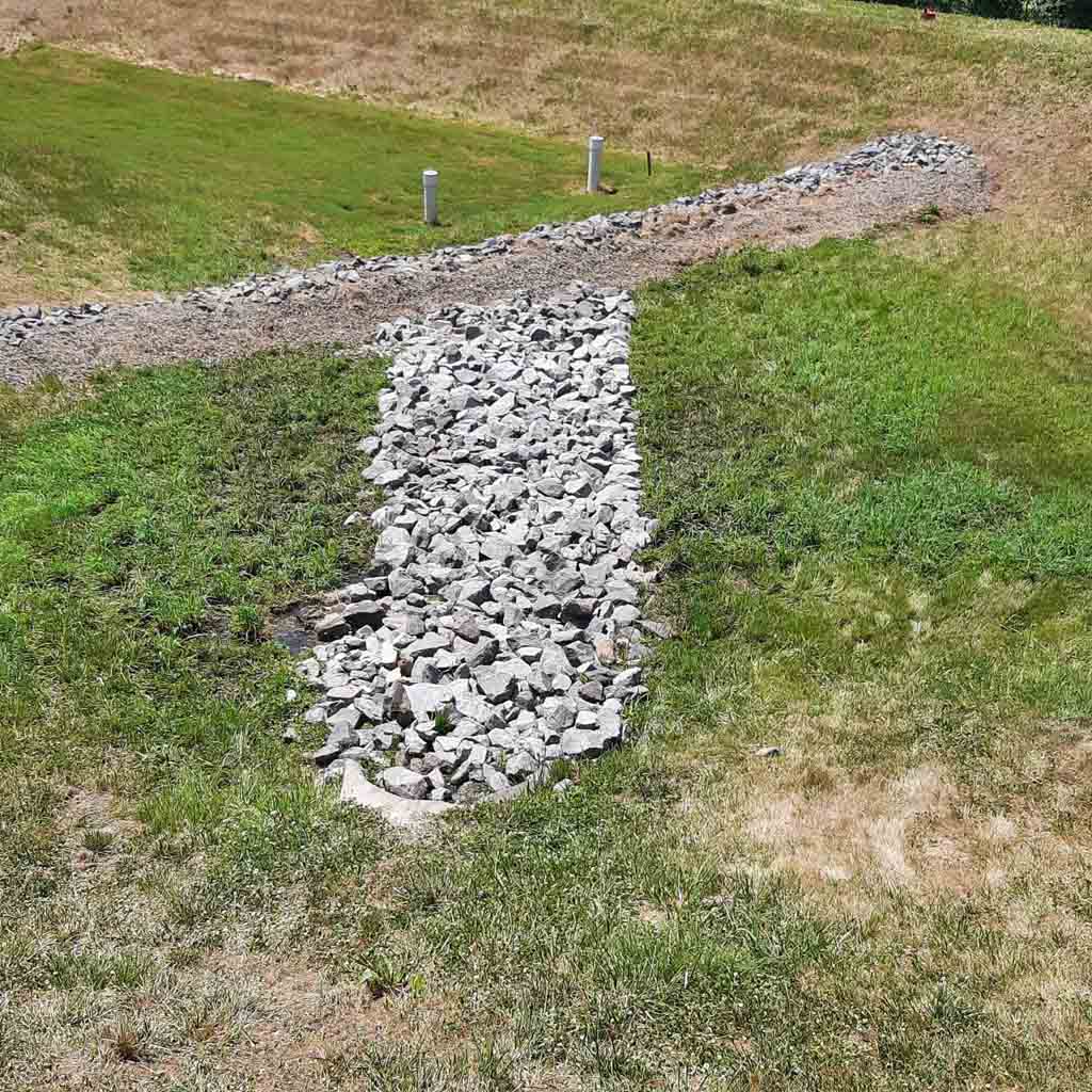 A newly added dry creek bed to an existing basin.