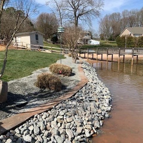 A very well placed and cleanly installed rock wall, bordering between the shoreline and a retention wall.