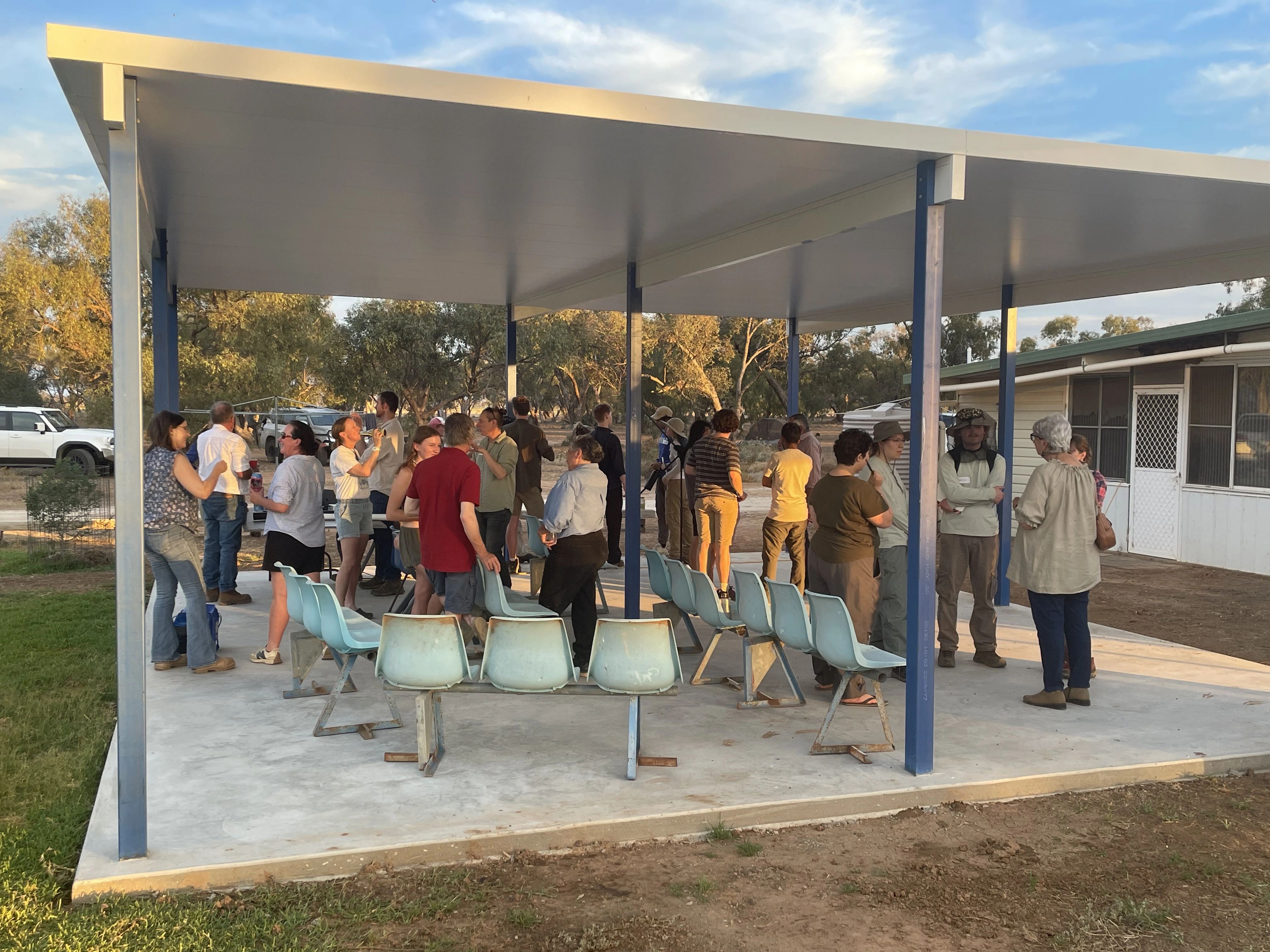 A group of people standing under a covered area.