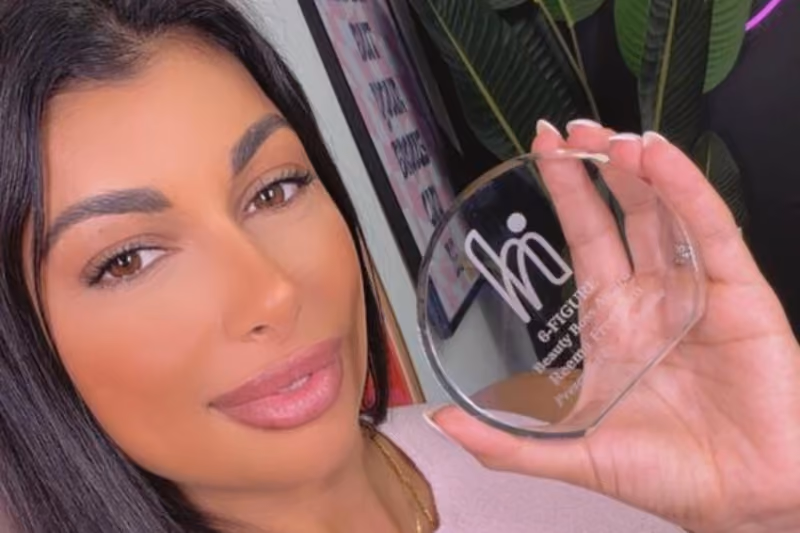 Woman holding a round glass beauty award at Highstoke